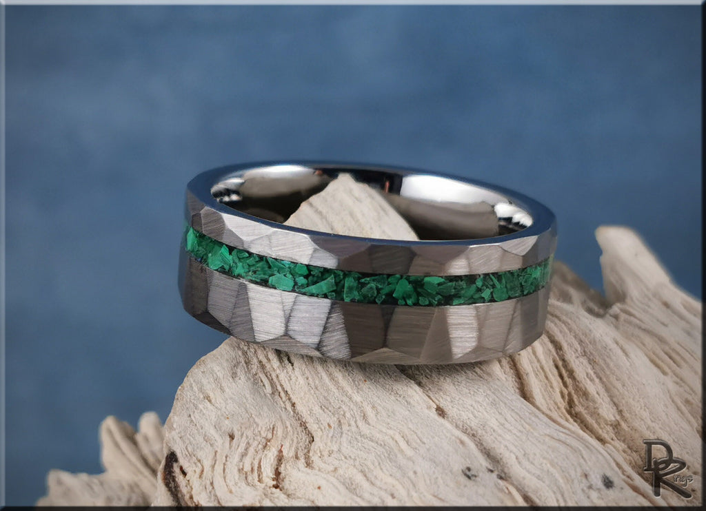 Hammered tungsten ring with malachite green stone inlay on natural wood background