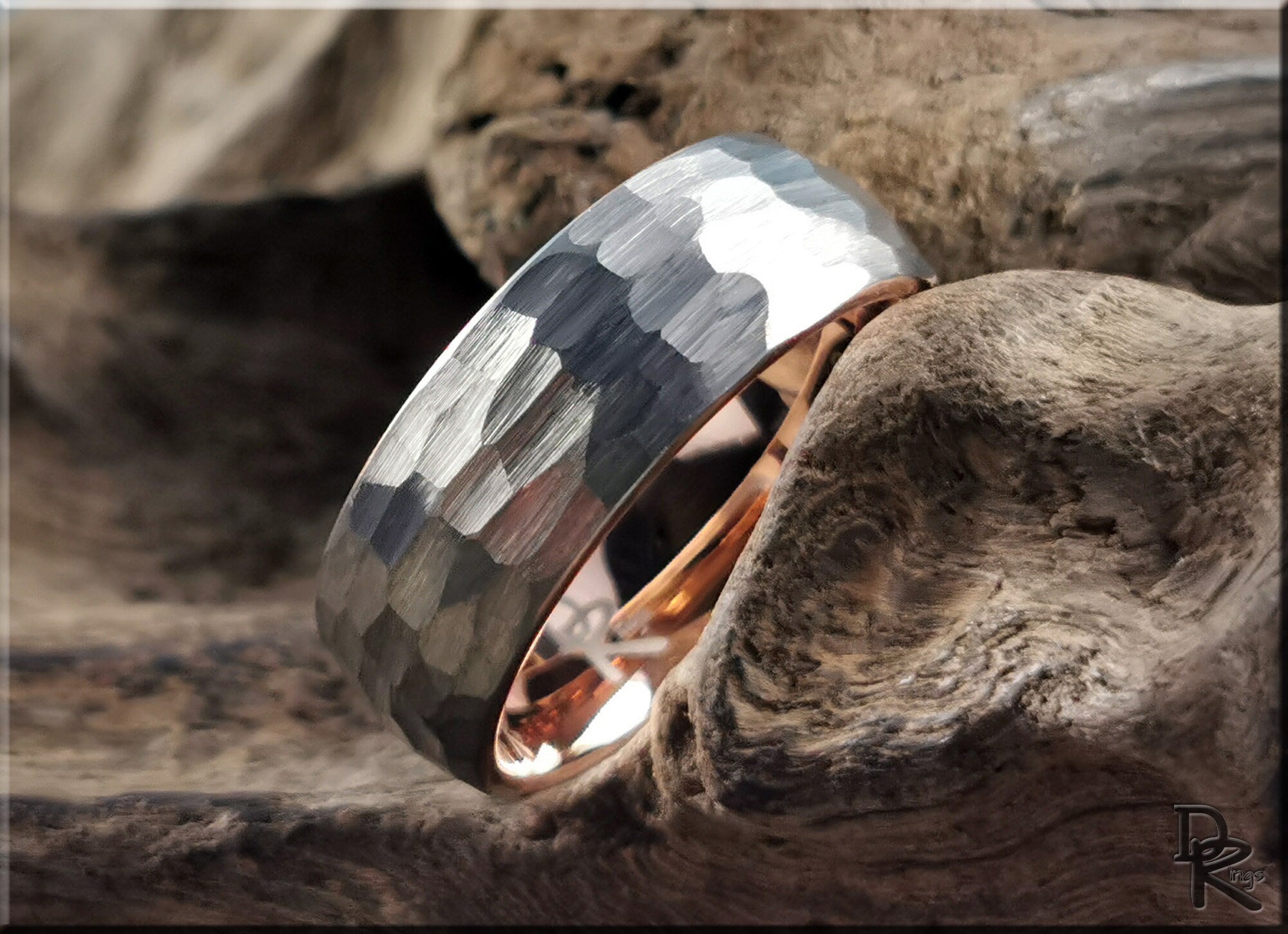 Hammered tungsten ring with rose gold core featuring a textured silver exterior and polished inner band
