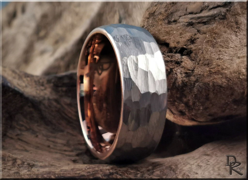 Hammered tungsten ring with rose gold core showcasing textured silver exterior and polished rose gold interior