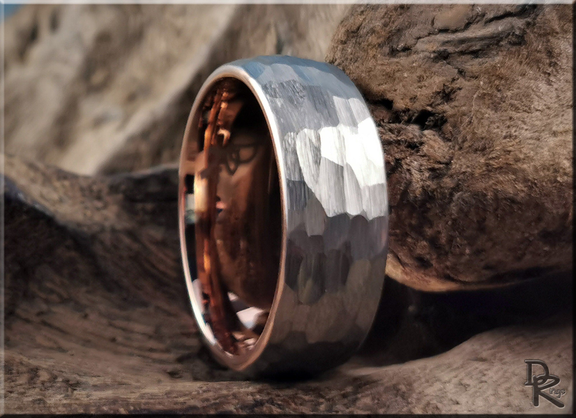 Hammered tungsten ring with rose gold core showcasing textured silver exterior and polished rose gold interior