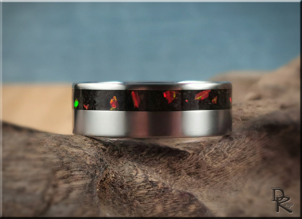 DR Rings titanium ring with inlay featuring a dark center with red and green accents on a silver band