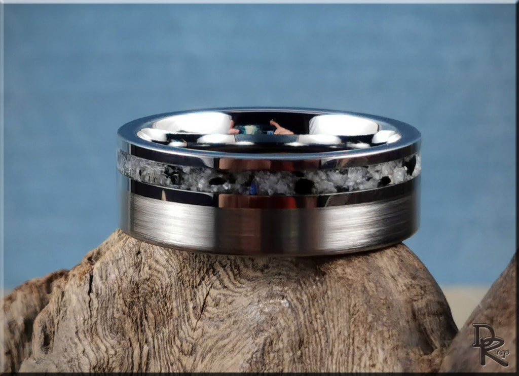 Tungsten carbide ring with moonstone inlay resting on natural wood background
