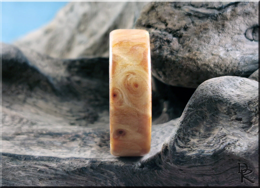 Natural wood ring on antler core with smooth finish displayed on rustic wooden background