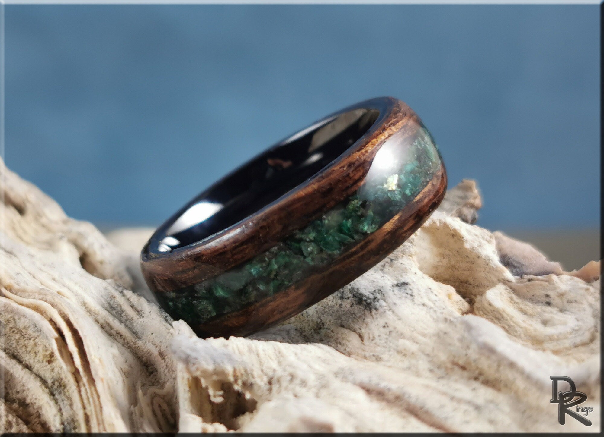 DR Rings wood ring with inlay featuring green stone and dark wood design on textured surface