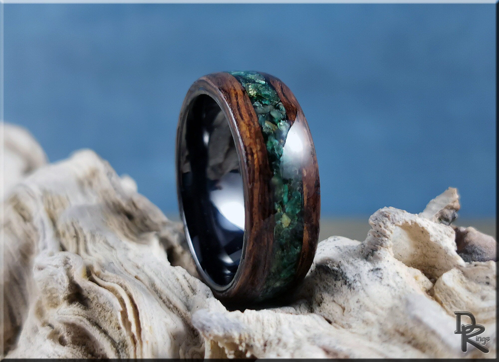 DR Rings wood ring with inlay featuring green stone and dark polished interior on driftwood background