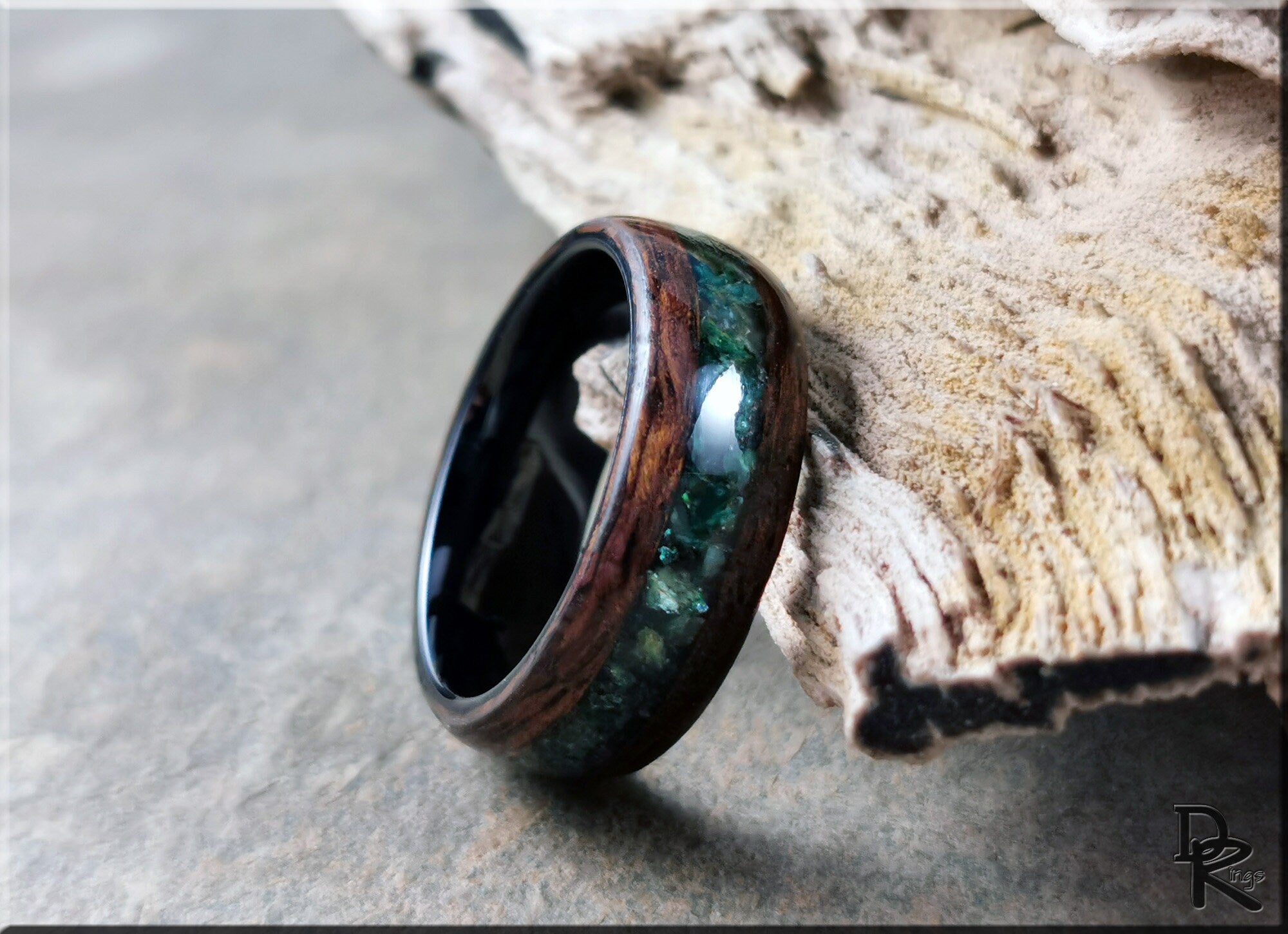 DR Rings wood ring with inlay featuring green resin and dark wood design on textured surface