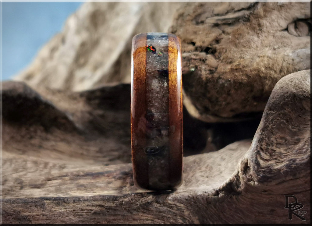 Wood ring with inlay on antler core displayed on textured natural wood background