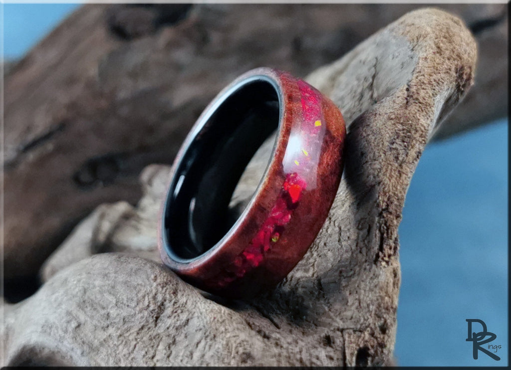 Wood ring with opal inlay featuring red iridescent stones set in a dark wood band by DR Rings