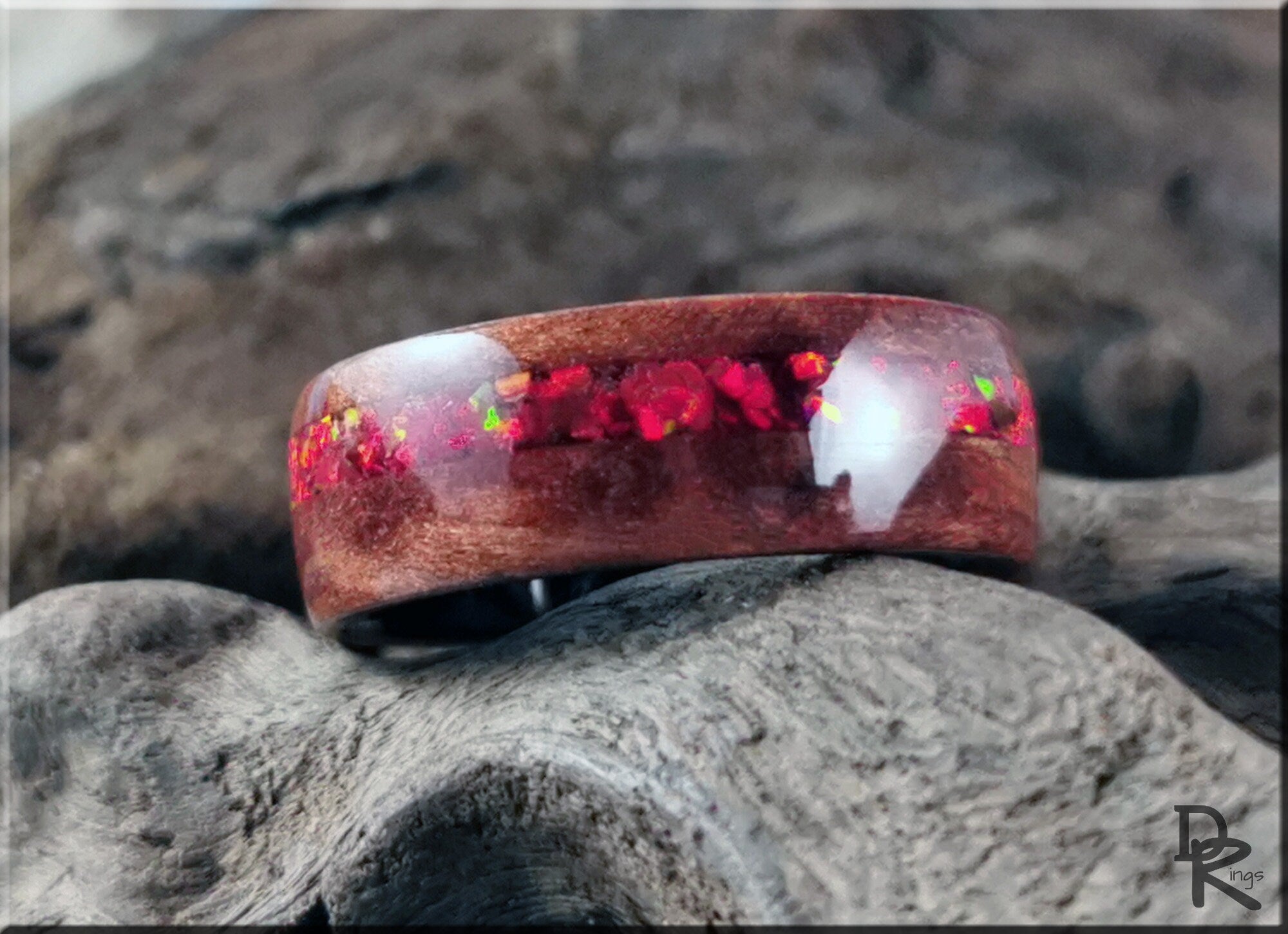 Wood ring with opal inlay featuring red opal fragments set in polished wood band by DR Rings
