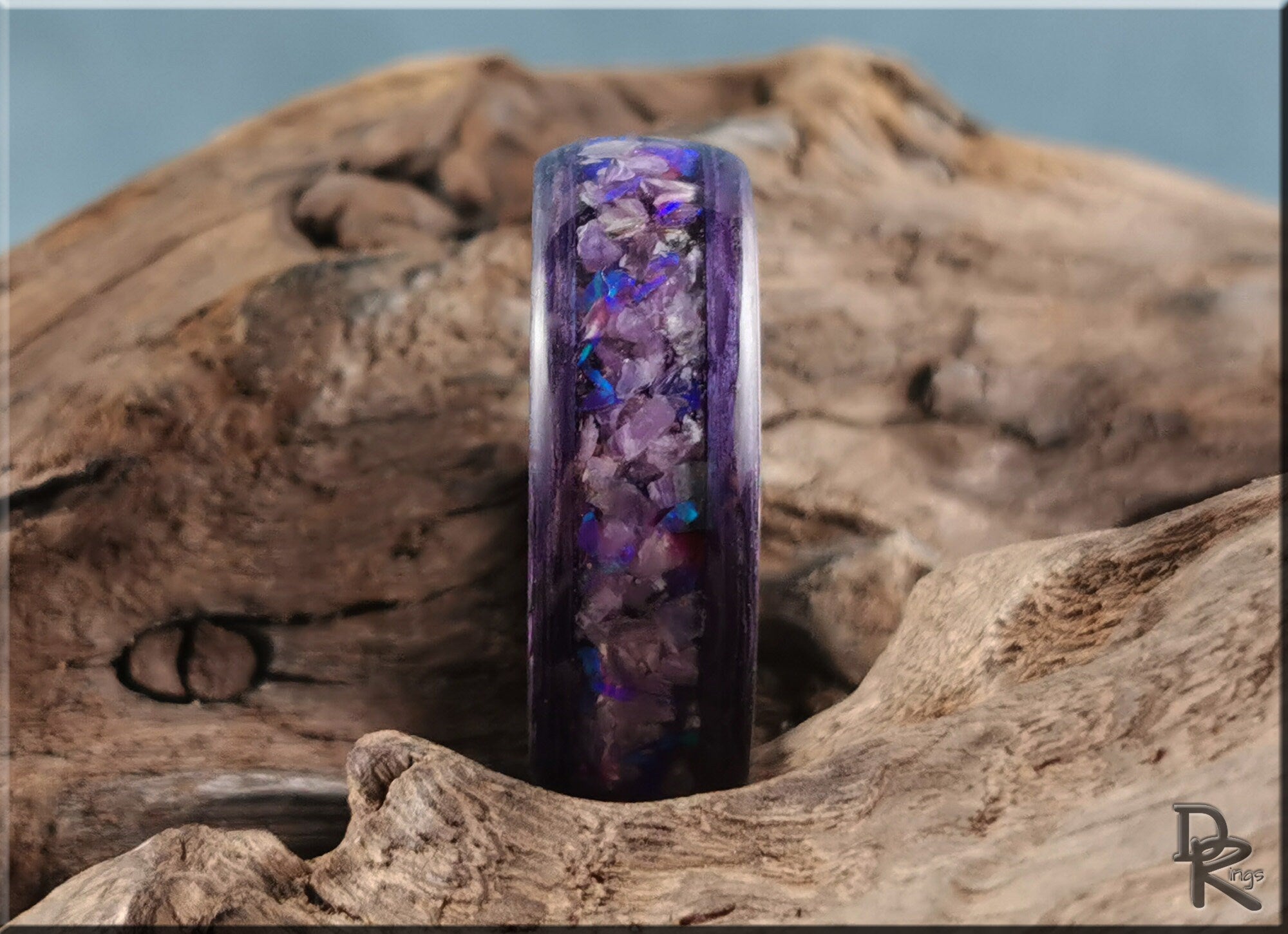 Purple wood ring with opal inlay by DR Rings displayed on natural wood background