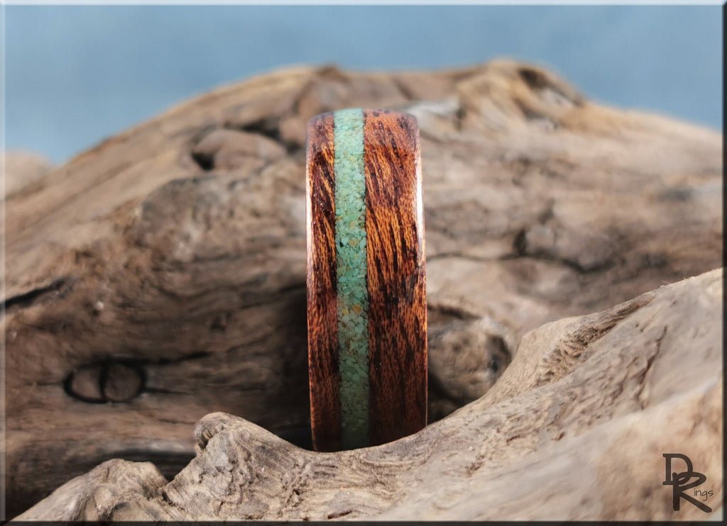 Wood ring with turquoise and antler inlay by DR Rings displayed on natural wood background