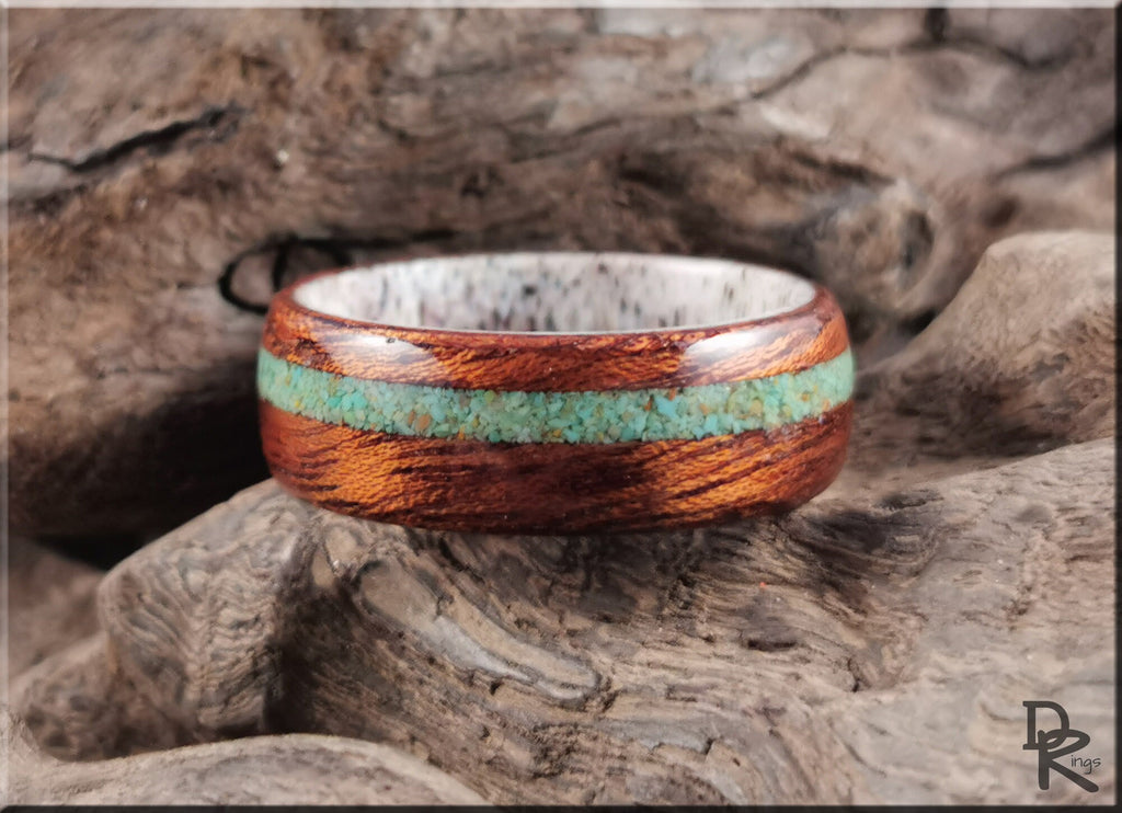 Wood ring with turquoise and antler inlay by DR Rings displayed on textured wood background